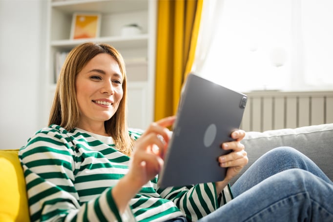 Woman sitting down looking at a tablet